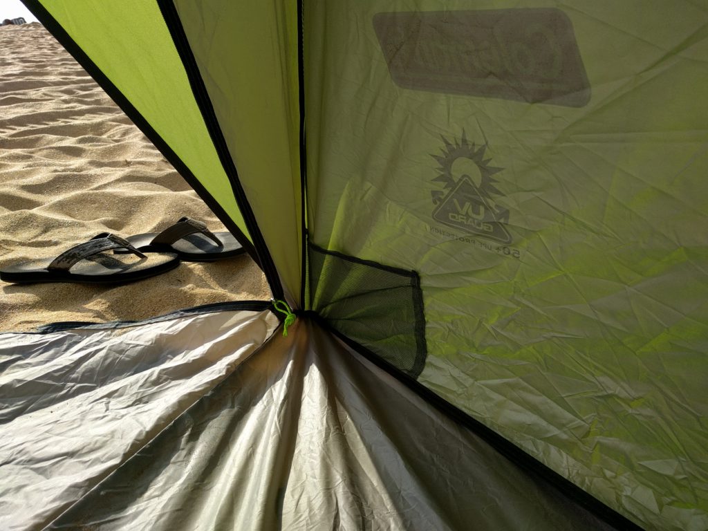A fabric mesh pock in the corner of a green tent.