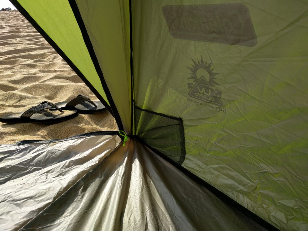 A fabric mesh pocket in the corner of a beach tent.