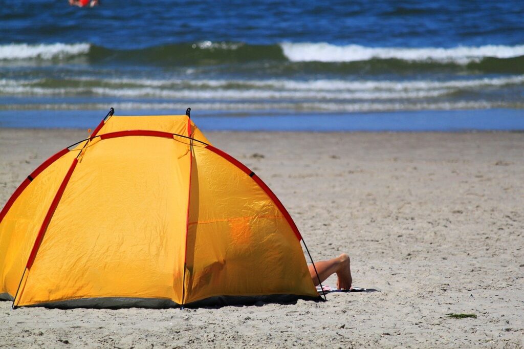 An orange beach tent, set up facing the ocean.