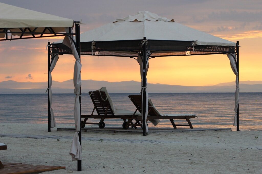 A pop-up beach canopy set up on a beach. The ocean is visible in the background.